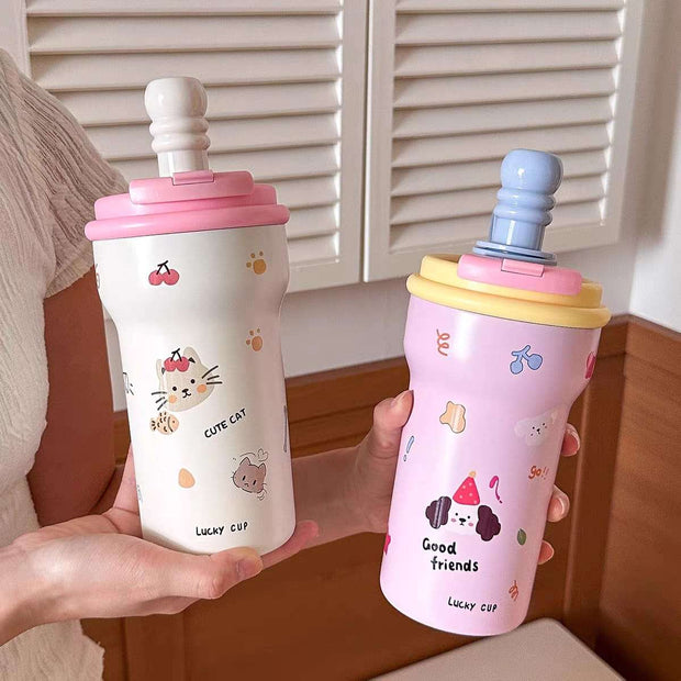 Two colorful children's cups with animal illustrations held by a person.