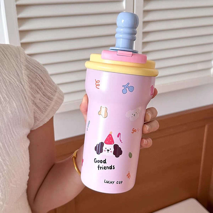 Person holding a pink tumbler with cartoon designs and colorful lid.