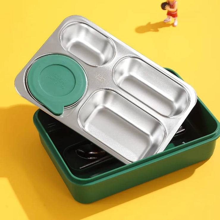 Stainless steel bento box with green lid and base on a yellow background