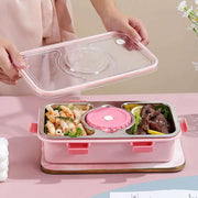 Pink bento box with food compartments on a pink surface