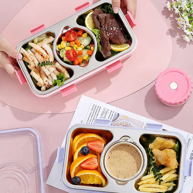 Bento box with compartments of food on a pink surface