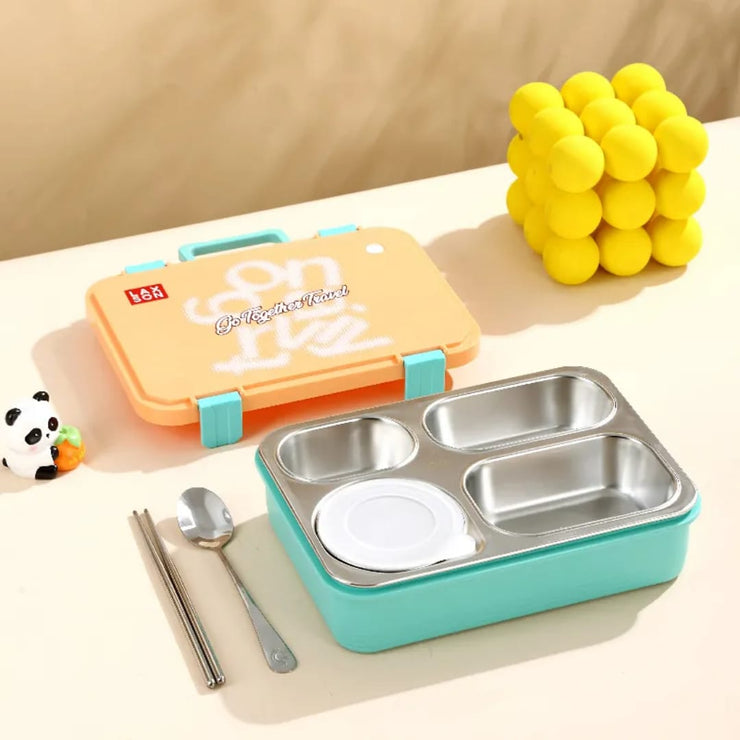 Children's lunch box with compartments, spoon, and yellow ball on a beige surface