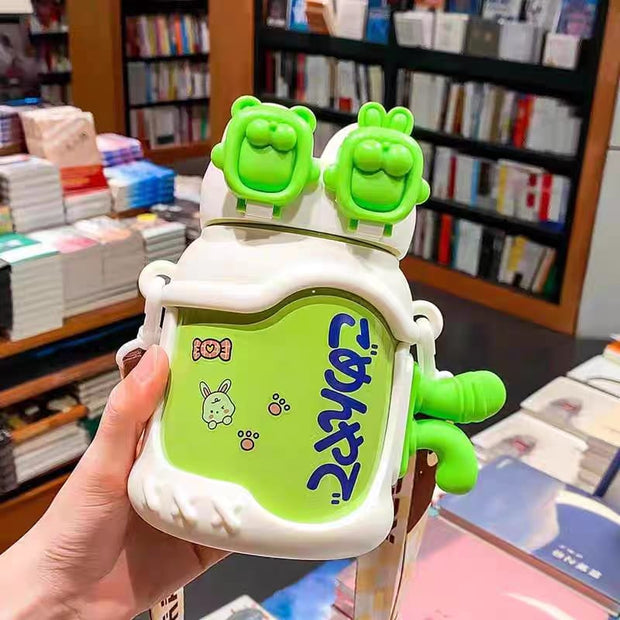 Green and white container with cartoon character design held in front of a bookshelf.