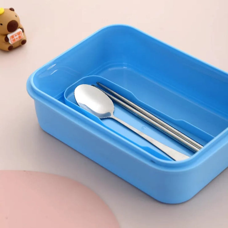 Blue plastic container with silver spoon and chopsticks on a light background